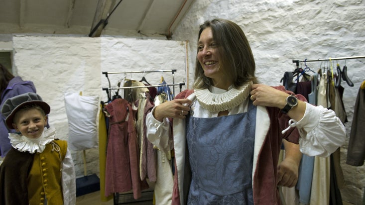A family tries on Tudor-inspired costumes in the Hayloft at Trerice, Cornwall